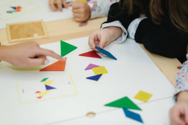 Masanın üzerinde farklı figürlerle oynayan çocukları kapatın.