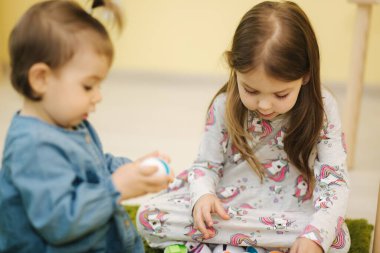Çocuklar anaokulunda oyuncak yumurtalarla oynarlar. Çocuk odası. Oğlanlar ve kızlar