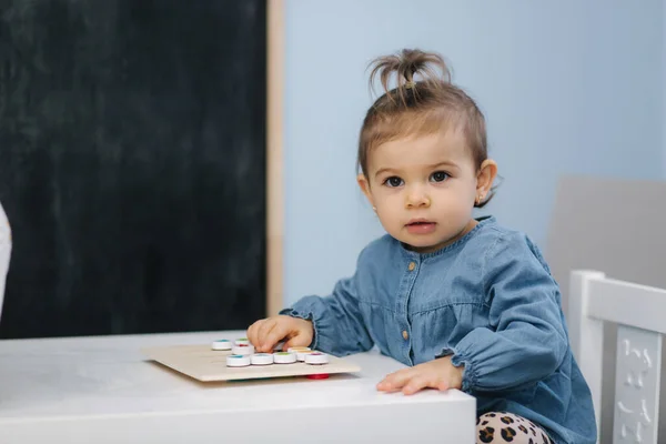 Ένα μωράκι στο παιδικό παιχνίδι. Κοριτσάκι με μπλου τζην πουκάμισο. Χαριτωμένο μωράκι στο παιδικό δωμάτιο — Φωτογραφία Αρχείου