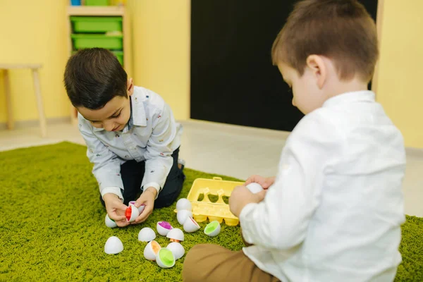 Los niños juegan con huevos de juguete en el jardín de infantes. Guardería. Niño y niñas — Foto de Stock