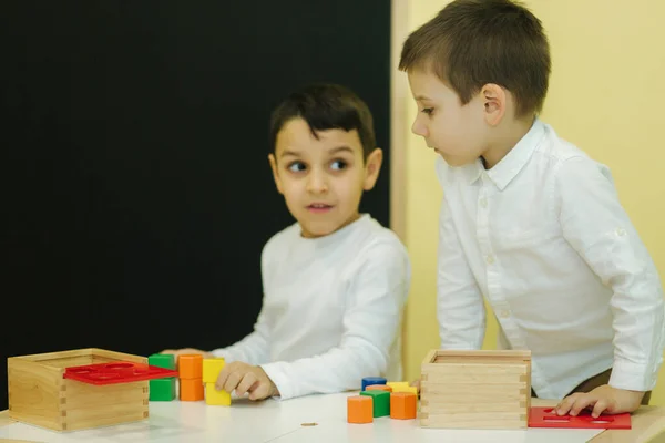 Niño jugar con diferentes figuras en el jardín de infantes. Los chicos juegan juntos en la guardería — Foto de Stock