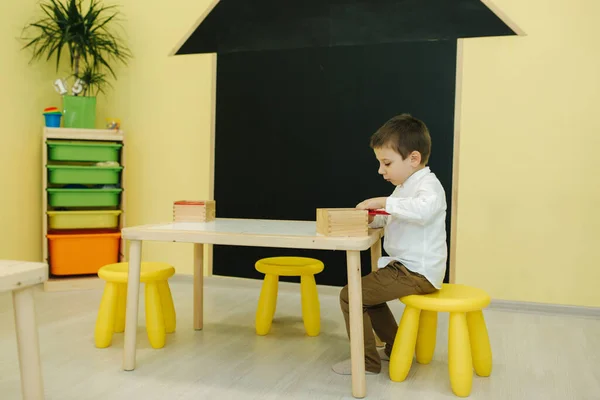 Niño jugar con diferentes figuras en el jardín de infantes. Los chicos juegan juntos en la guardería — Foto de Stock