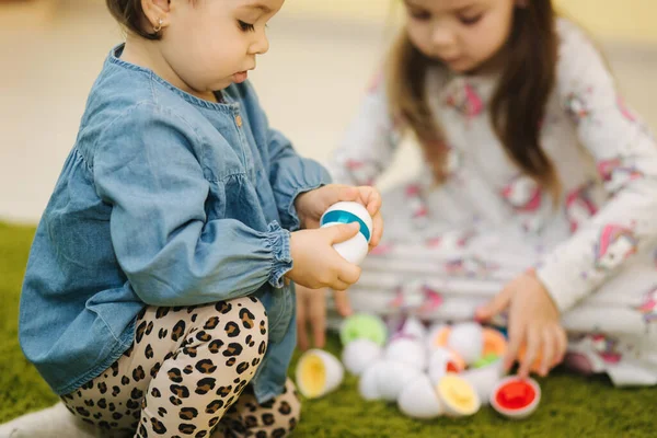 Los niños juegan con huevos de juguete en el jardín de infantes. Guardería. Niño y niñas — Foto de Stock
