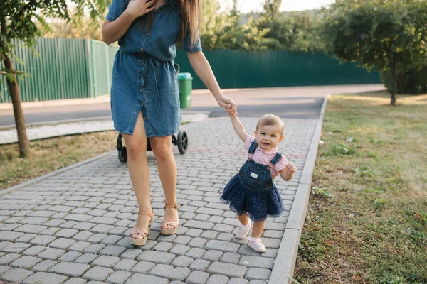 Första steget av bedårande liten flicka i sommarparken. Mamma och dotter — Stockfoto