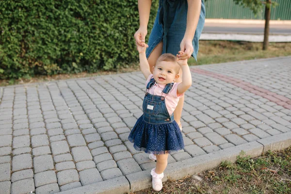 Första steget av bedårande liten flicka i sommarparken. Mamma och dotter — Stockfoto