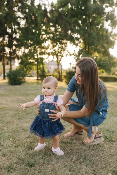 Primul pas al fetiței adorabile în parcul de vară. Mama și fiica merg pe jos — Fotografie, imagine de stoc