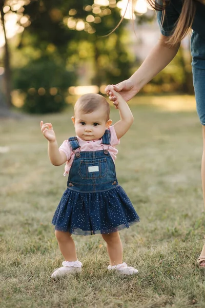 Primer paso de adorable niña en el parque de verano. Mamá e hija caminando — Foto de Stock