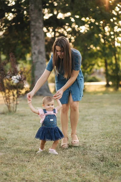 Primul pas al fetiței adorabile în parcul de vară. Mama și fiica merg pe jos — Fotografie, imagine de stoc