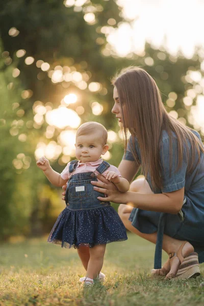 Primeiro passo da adorável menina no parque de verão. Mãe e filha andando — Fotografia de Stock