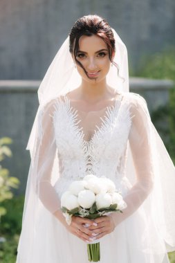 Düğününde bir buket beyaz çiçekli zarif gelinlik içinde çok güzel bir gelin.