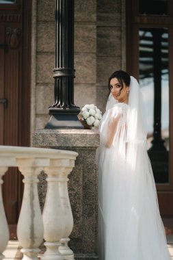 Düğününde bir buket beyaz çiçekli zarif gelinlik içinde çok güzel bir gelin.