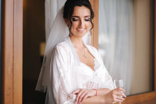 Retrato de novia hermosa con copa de champán en el hotel por la mañana. Encantadora mujer con gran peinado y maquillaje —  Fotos de Stock