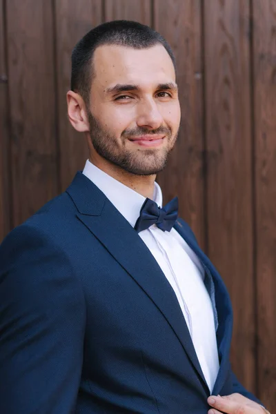 Porträt eines gutaussehenden bärtigen Bräutigams im dunkelblauen Anzug — Stockfoto