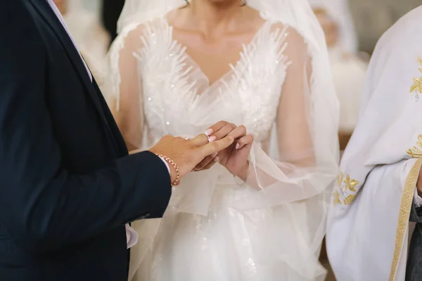 Κλείστε τα χέρια του γαμπρού και της νύφης στην εκκλησία. γάμος — Φωτογραφία Αρχείου