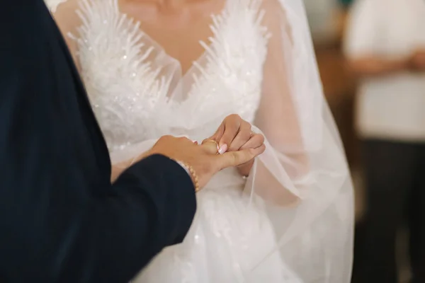 Közelíts a vőlegény és a menyasszony kezére a templomban. esküvő. — Stock Fotó