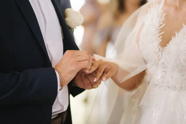 Närbild händer brudgum och brud i kyrkan. bröllop — Stockfoto