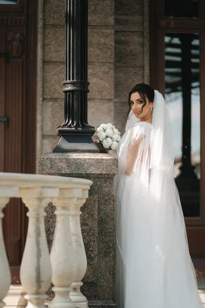 Superbe mariée dans une élégante robe de mariée avec bouquet de fleurs blanches dans son jour de mariage — Photo