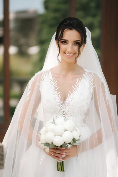 Splendida sposa in elegante abito da sposa con mazzo di fiori bianchi nel giorno del suo matrimonio — Foto Stock