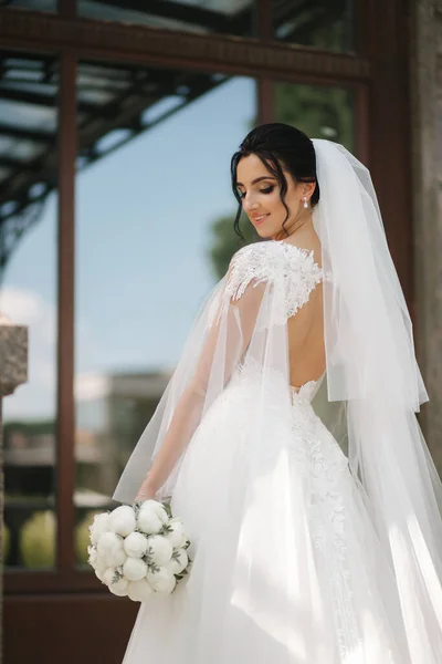 Linda noiva em vestido de noiva elegante com buquê de flores brancas em seu dia do casamento — Fotografia de Stock