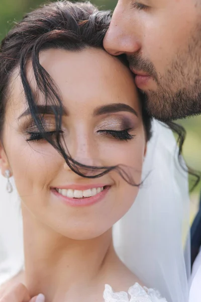 Feche o retrato da noiva de beijo de noivo no templo. Belos e elegantes recém-casados — Fotografia de Stock