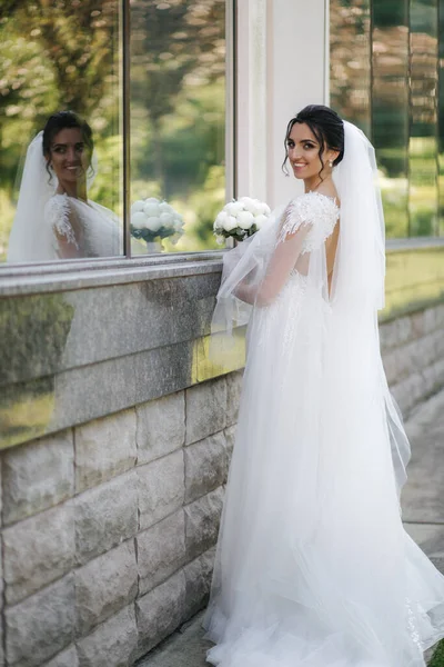 Linda noiva em vestido de noiva elegante com buquê de flores brancas em seu dia do casamento — Fotografia de Stock