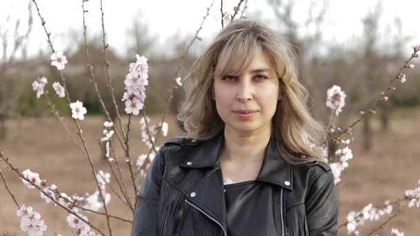 Una donna cammina vicino all'albero dei fiori. Femmina fuori — Video Stock