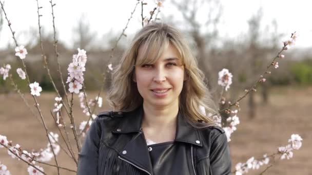 A mulher anda perto da árvore da flor. Feminino fora — Vídeo de Stock