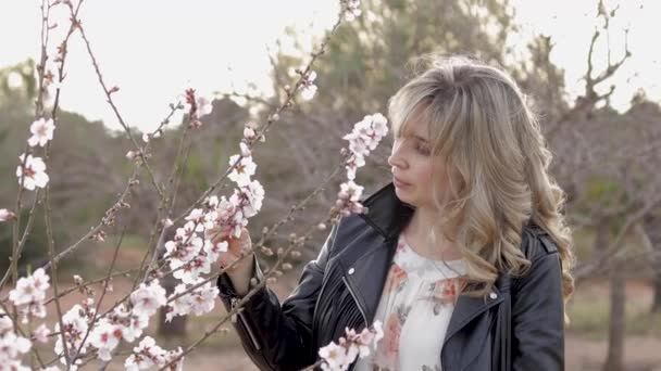 A mulher anda perto da árvore da flor. Feminino fora — Vídeo de Stock