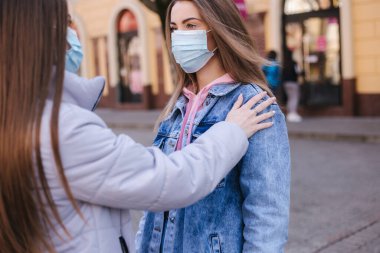 Maskeli kızlar. Coronavirus teması. Şehirdeki kadınlar karantina sırasında yürür