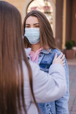 Maskeli kızlar. Coronavirus teması. Şehirdeki kadınlar karantina sırasında yürür
