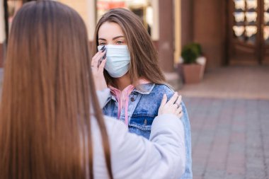 Maskeli kızlar. Coronavirus teması. Şehirdeki kadınlar karantina sırasında yürür
