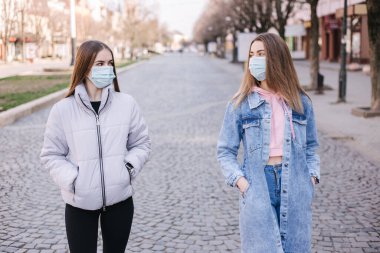 Maskeli kızlar. Coronavirus teması. Şehirdeki kadınlar karantina sırasında yürür