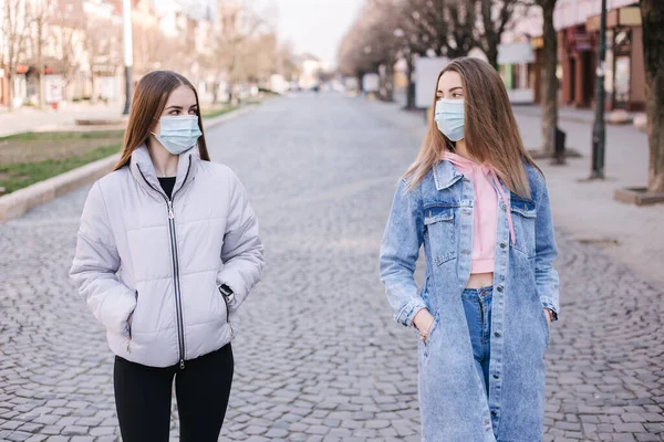 Maskeli kızlar. Coronavirus teması. Şehirdeki kadınlar karantina sırasında yürür — Stok fotoğraf