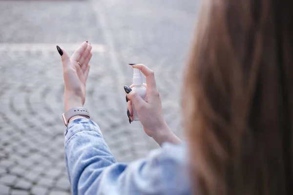 Primer plano de la mano de las mujeres. Hembra en mascarilla uso desinfectante —  Fotos de Stock