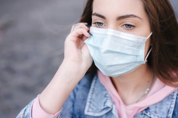 Maskeli kız. Coronavirus teması. Şehirdeki kadınlar, karantina sırasında. Şehirde tek başına. Kadın kullanıcı telefonu — Stok fotoğraf