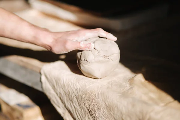 Close up of man works with clay. Male potter kneads and moistens the clay before work, toned — Stock Photo, Image