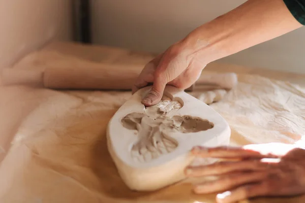Le mani di vasaio riempiono il modulo di una ceramica a forma di farfalla. Primo piano delle mani — Foto Stock