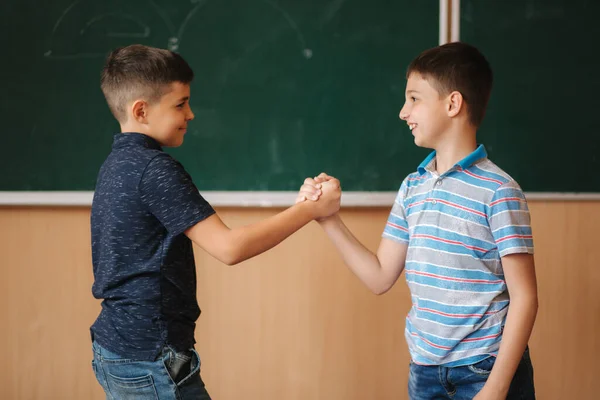 Два школьника стоят перед доской в классной комнате. — стоковое фото