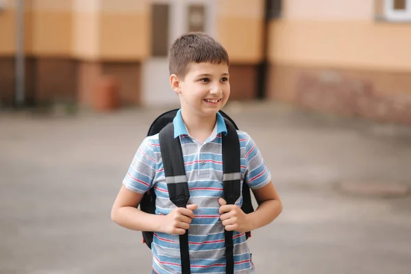 Słodki chłopczyk z plecakiem wraca do domu po zajęciach. — Zdjęcie stockowe