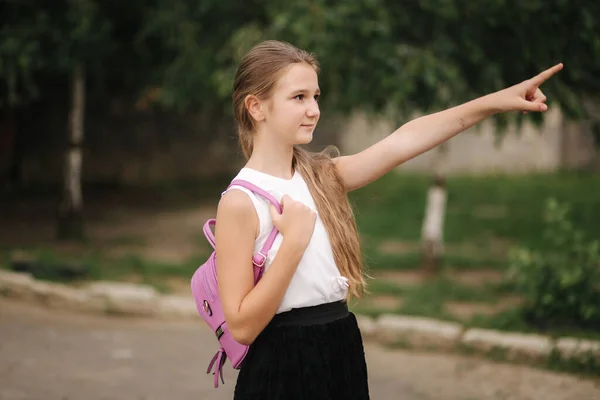 Mladá dívka procházky v parku s batohem — Stock fotografie
