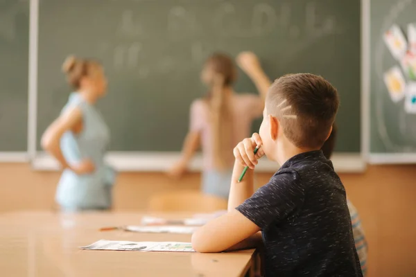 Schülerin schreibt etwas auf Tafel im Klassenzimmer — Stockfoto