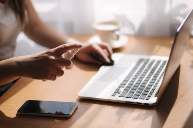 Evdeki kadın ellerini dezenfektan jel kutusuyla kapat. Evde tecrit, karantina. Coronavirus konsepti. Temizleyici kullanan bir kadın dizüstü bilgisayar.