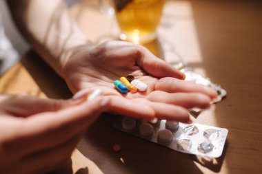 Kadın eli hapları yakın tut. Haplı el ve limonlu siyah çay. Dokunulmazlık. Vitaminler