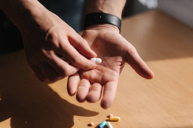 Erkeklerin ellerinde bir sürü renkli hap var. Elinde saat olan bir adam. Coronavirus konsepti