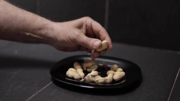Närbild av mans hand försöka öppna jordnötter — Stockvideo