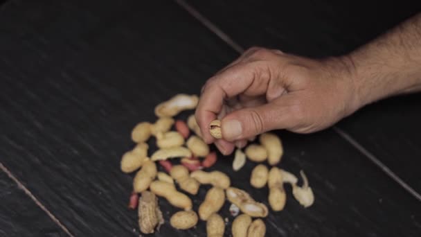 Närbild av mans hand försöka öppna jordnötter — Stockvideo