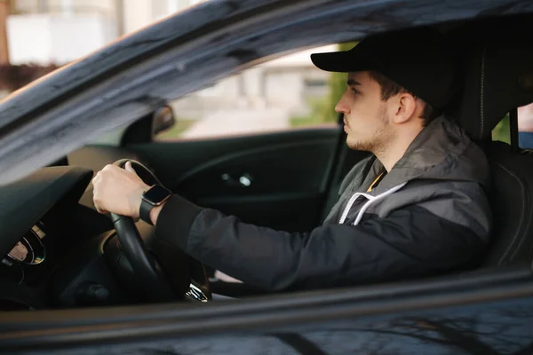 El hombre se sienta en el coche. Joven guapo conduciendo un coche — Foto de Stock