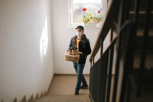 El hombre entrega pizza y café al cliente en máscara y guantes. Tema Coronavirus — Foto de Stock