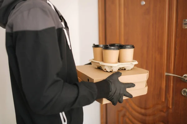 Man leverans pizza och kaffe till kund i mask och handskar. Tema för Coronavirus — Stockfoto