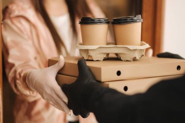 Teslimatçı çocuğu kapat ve müşteriye sipariş ver. Pizza ve kahve devilery. Eldivenli teslimatçı çocuk ve müşteri.